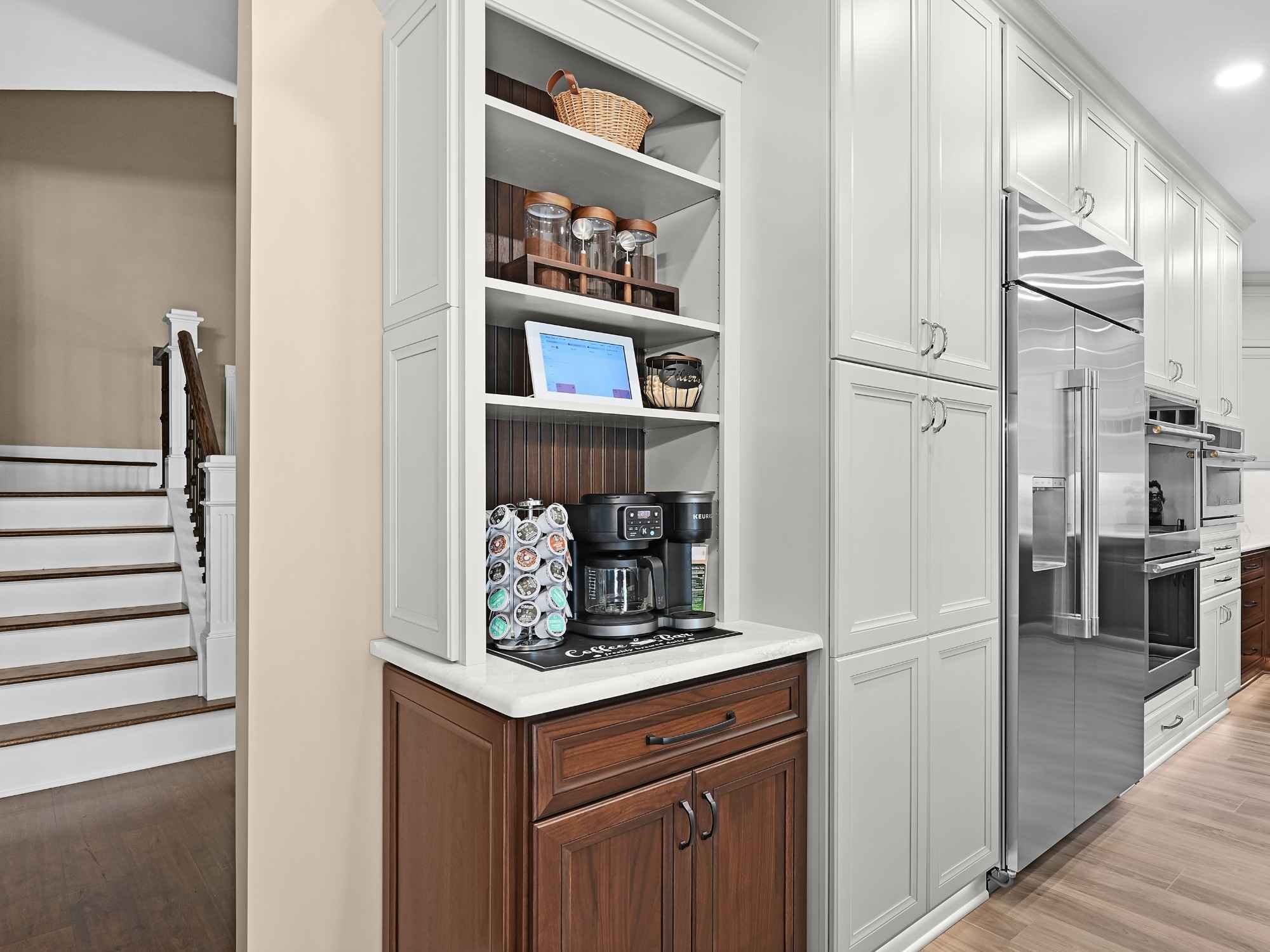 Remodeled kitchen and foyer in an Aurora, IL home featuring new stairs, flooring, kitchen cabinetry, and a dedicated coffee station by J&J Construction.