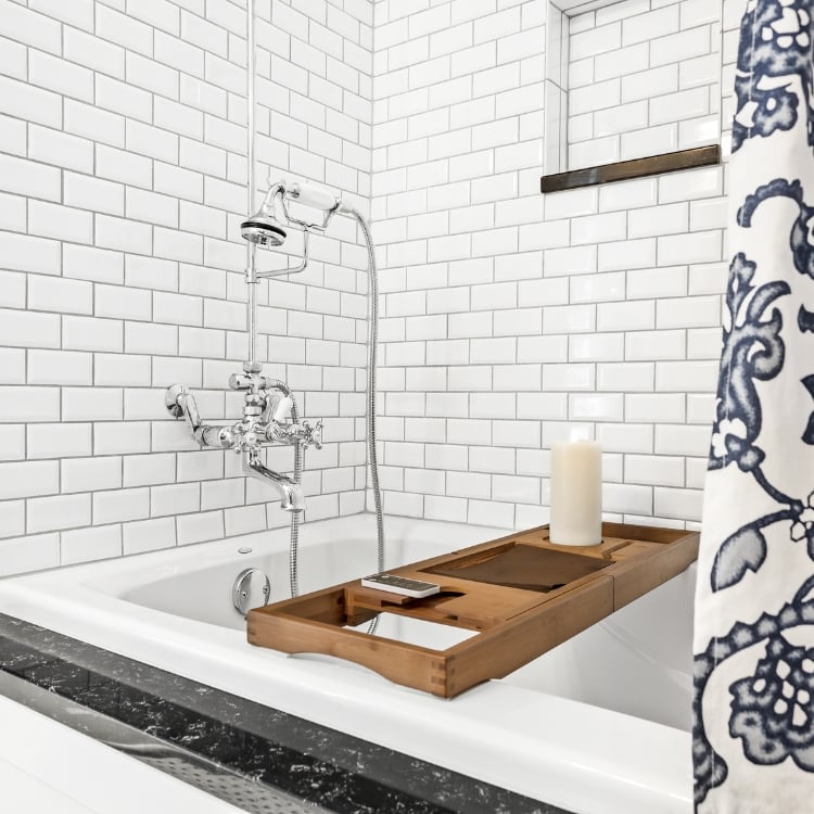 vintage tub with vintage inspired plumbing fixtures subway tile and quartz tub ledge