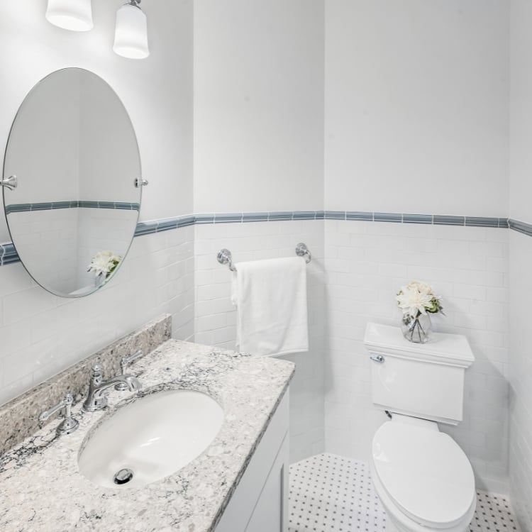 Image of the vanity, mirror, and the toilet installed in a bathroom remodel by J&J Construction
