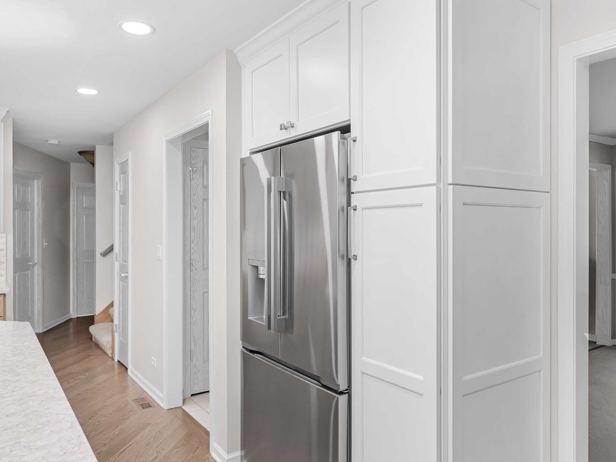 Image of kitchen remodel in Naperville, IL featuring built in fridge, tall cabinetry, and clean modern layout by J and J Construction