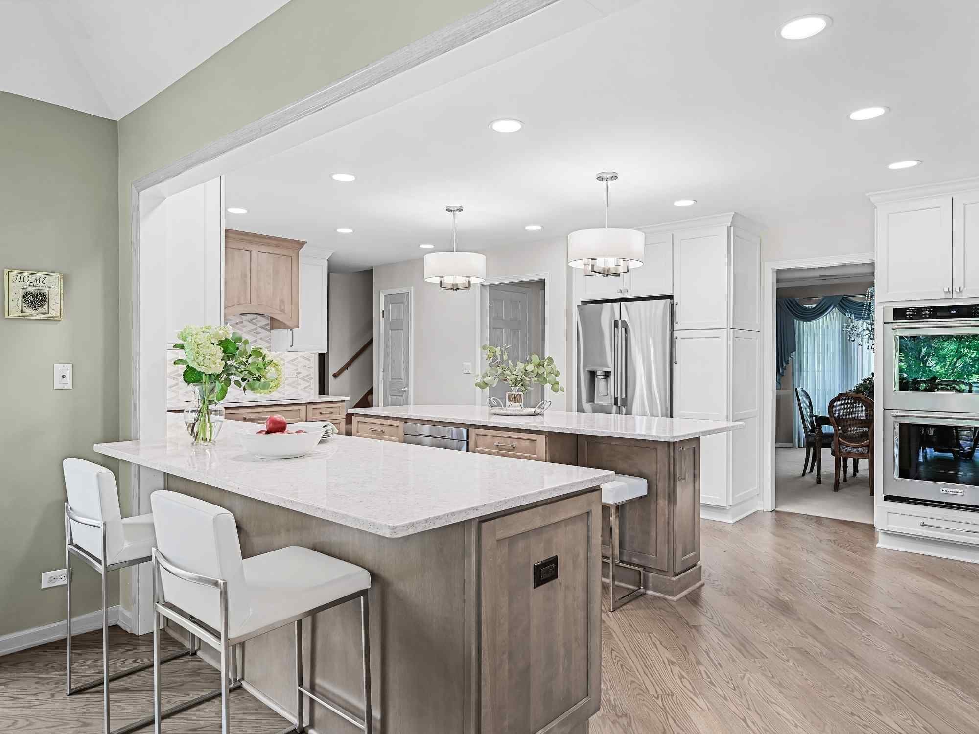 Image of kitchen remodel in Naperville, IL featuring dual islands, open layout, wood cabinetry and stainless appliances by J and J Construction