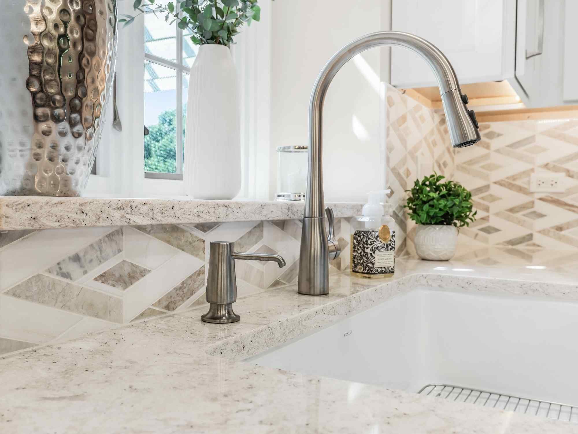 Image of kitchen remodel in Naperville, IL featuring tile backsplash, modern faucet, soap dispenser and window sink area by J and J Construction