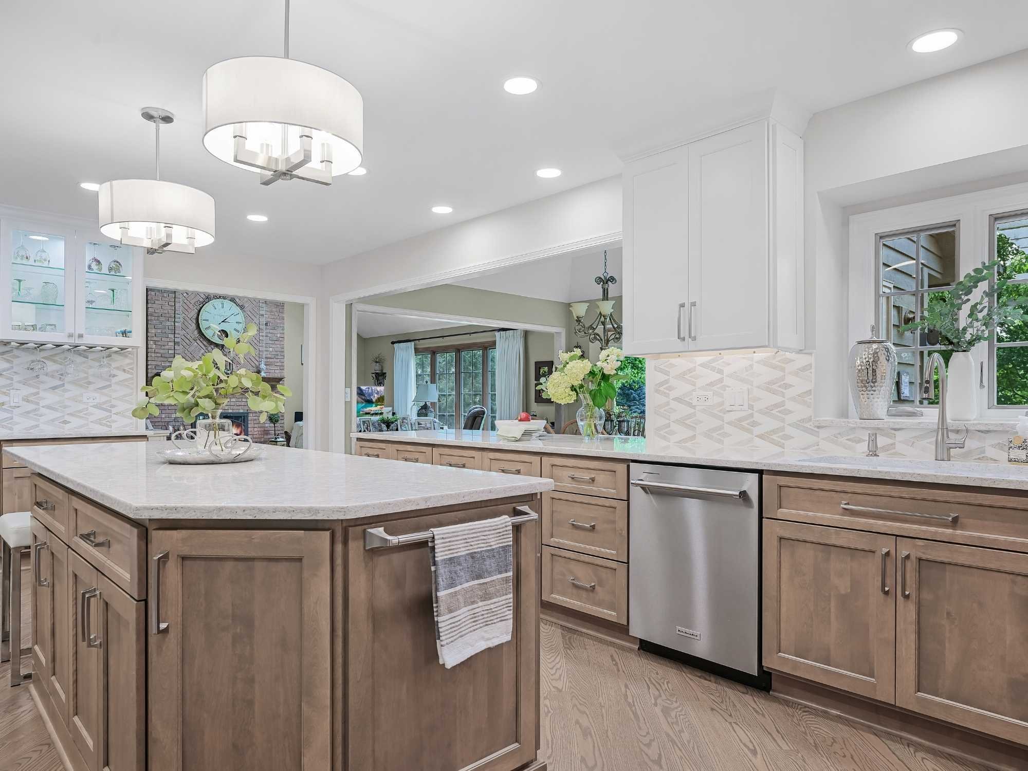 Image of kitchen remodel in Naperville, IL featuring wood cabinets, open layout, stainless dishwasher and tile backsplash by J and J Construction