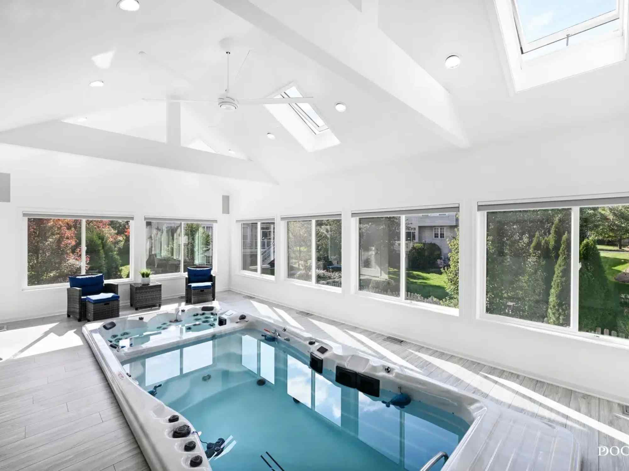 Photo of indoor spa room addition in Plainfield IL by J&J Construction featuring hot tub, vaulted ceiling, and natural light